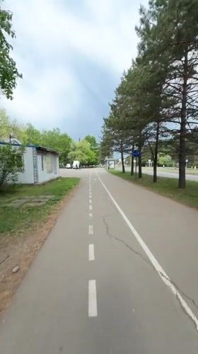 Woman cycles tree-lined bike path in Birobidzhan, Russia