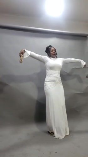 Woman dances with gold object in Onitsha photo studio