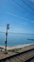 Train passenger records trackside view with pebbles and vegetation