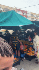 Turkish market bustling with produce vendors, clothing stalls documented