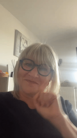 Woman waves to camera inside French residence early morning
