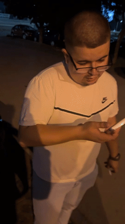 Man feeds stray cat on Varna street at night