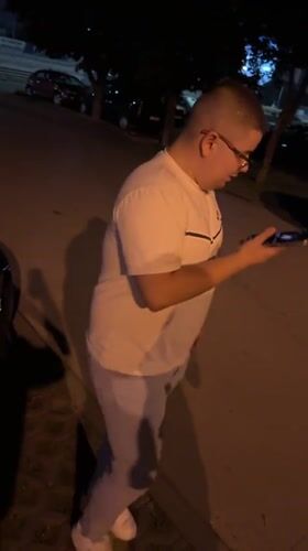 Man feeds stray cat on Varna street at night