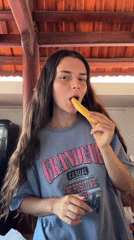 Woman enjoys mango snack indoors in Mũi Né