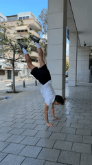 Young man performs handstand on Tel Aviv sidewalk
