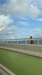 Person stands on Miami bridge overlooking water at night