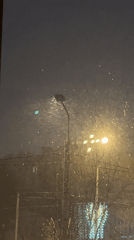 Light snowfall observed at night through window view