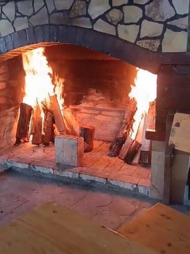 Roaring fire in a stone fireplace, Konush, Bulgaria