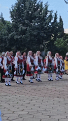 Bulgarian folk dancers perform traditional dance on brick plaza