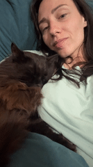 Woman rests with cat on chest in Saint Petersburg