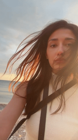 Woman captures sunset selfies at Montenegro beach with local wildlife