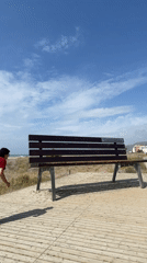 Man visits Castelldefels beach as maintenance tractor works shoreline