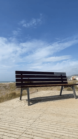 Man visits Castelldefels beach as maintenance tractor works shoreline