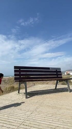 Man visits Castelldefels beach as maintenance tractor works shoreline