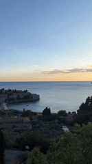 Tourists document sunset views of Montenegro's historic Sveti Stefan island