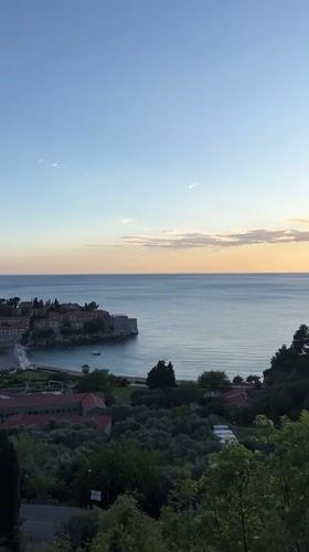 Tourists document sunset views of Montenegro's historic Sveti Stefan island