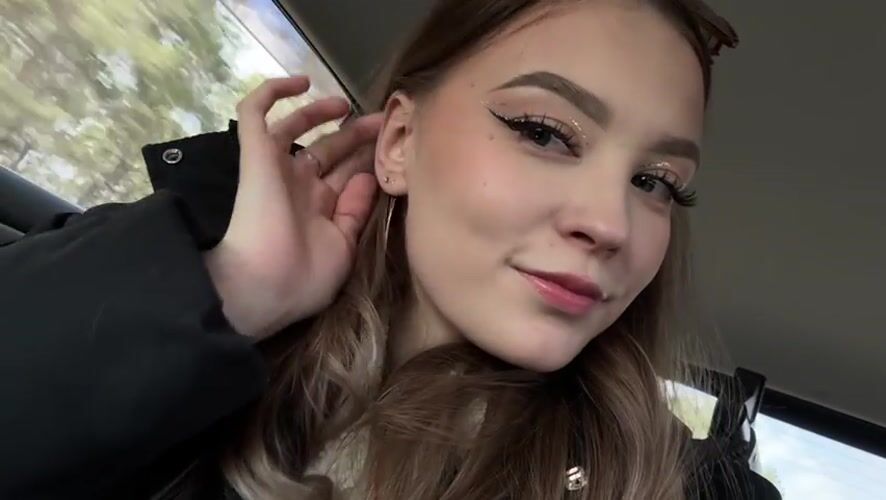 Woman poses for camera in car passenger seat, Yakutsk