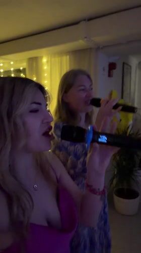 Two women enjoy karaoke night in Boreti, Montenegro