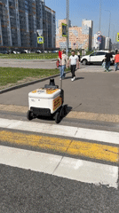 Delivery robot crosses crosswalk with pedestrians in Murino, Russia