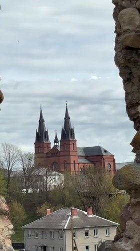 Tourist documents historic Rezekne ruins with dandelions, church views