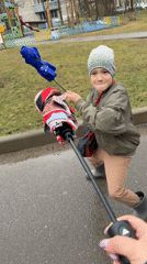 Boy plays with umbrellas on wet walkway in Dmitrov