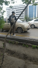 Man with backpack stands on street curb early morning
