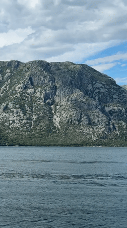 Small boats cross choppy bay waters near Prčanj, Montenegro