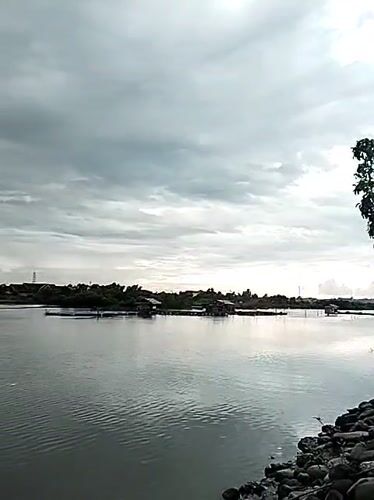 Quiet coastal morning in Lhokseumawe — water, fishing, and street life