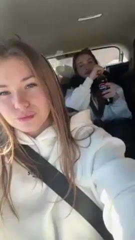 Three young women are in a car, apparently traveling somewhere. The woman in the front seat is filming a selfie video. All three are wearing white sweatshirts. The woman in the middle is holding a bottle of Pepsi. The music is upbeat.