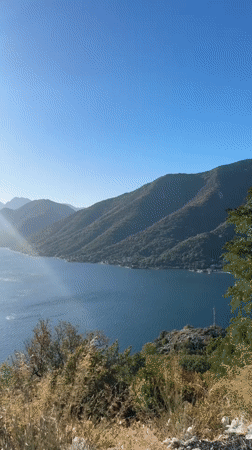 Sunlit bay and mountain reflections along the Montenegro coast