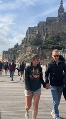 Tourists explore Mont Saint-Michel abbey on sunny afternoon