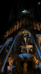 Crowds gather at illuminated Sagrada Familia in Barcelona evening