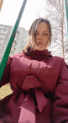 Woman enjoys sunny day swinging outdoors in Ust-Ilimsk