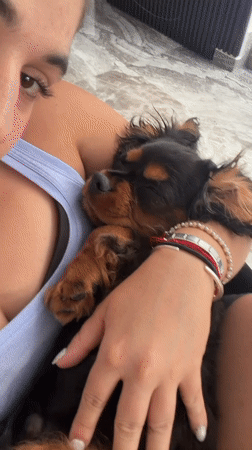 Woman holds sleeping puppy in Puebla, Mexico