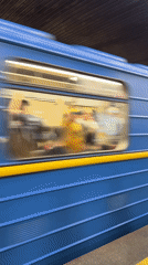 Blue-yellow train passes through Kyiv subway station