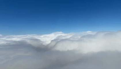 Passenger films aerial views of NYC skyline during cloudy flight