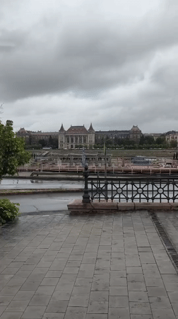 Wet walkway view captures Budapest riverside architecture