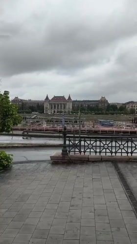 Wet walkway view captures Budapest riverside architecture