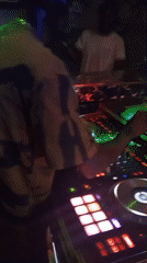 DJ performs with professional setup in blue-lit venue
