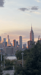 NYC skyline at golden hour, Empire State Building glowing purple