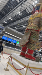 Airport terminal activity documented in Thailand featuring decorative statue