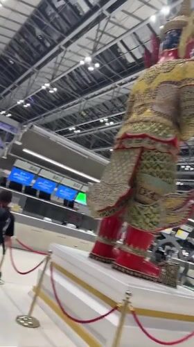 Airport terminal activity documented in Thailand featuring decorative statue