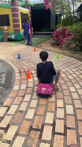 Child plays on toy car course in Porlamar