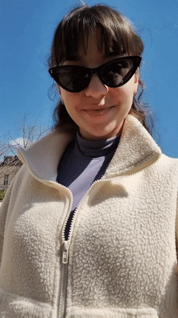 Woman walks past memorial pillars in sunny Sliven morning