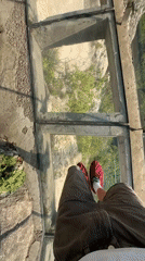 Tourist visits glass bridge overlook in Yongding District mountains