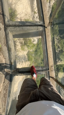 Tourist visits glass bridge overlook in Yongding District mountains