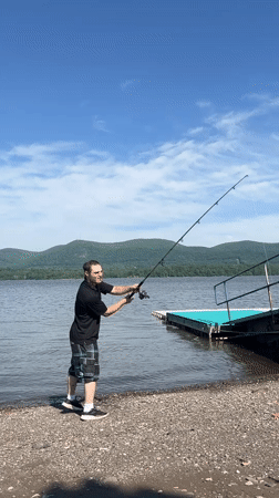 Man fishes from pebble beach at Newburgh lake