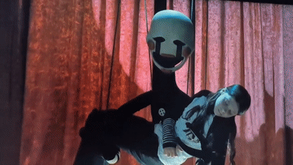 Puppet theater performance on a checkered stage with red curtains