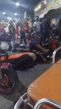 Emergency responders attend woman near motorcycle in Tinaquillo street