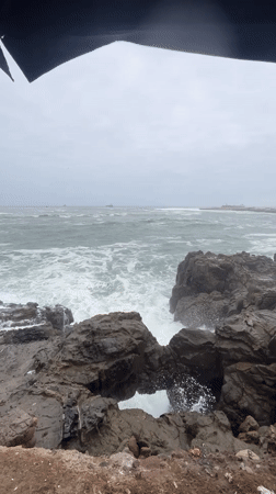 Rough seas crash against rocky coastline in Arica, Chile